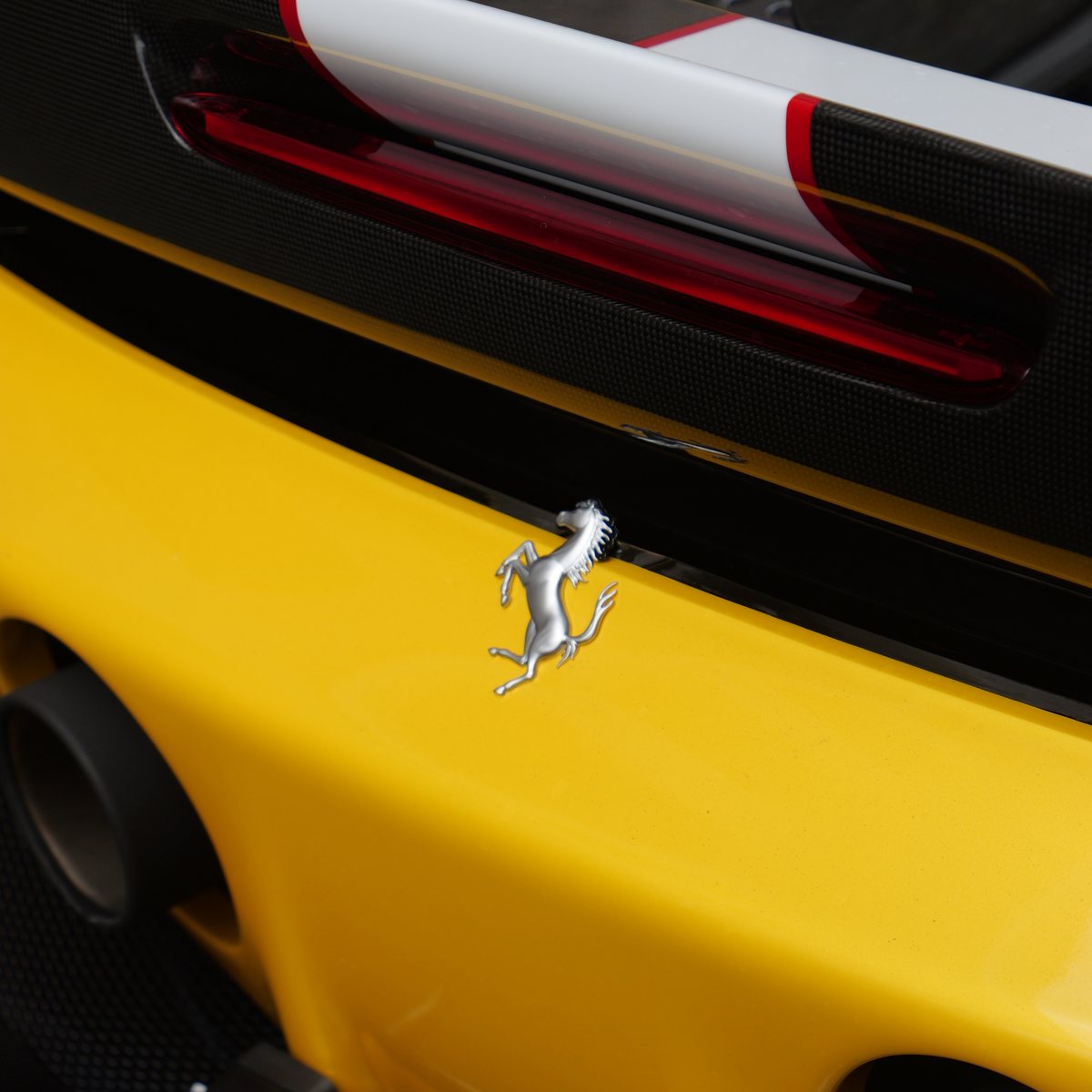 Silbernes springendes Pferd auf dem gelben Heck eines Sportwagens
