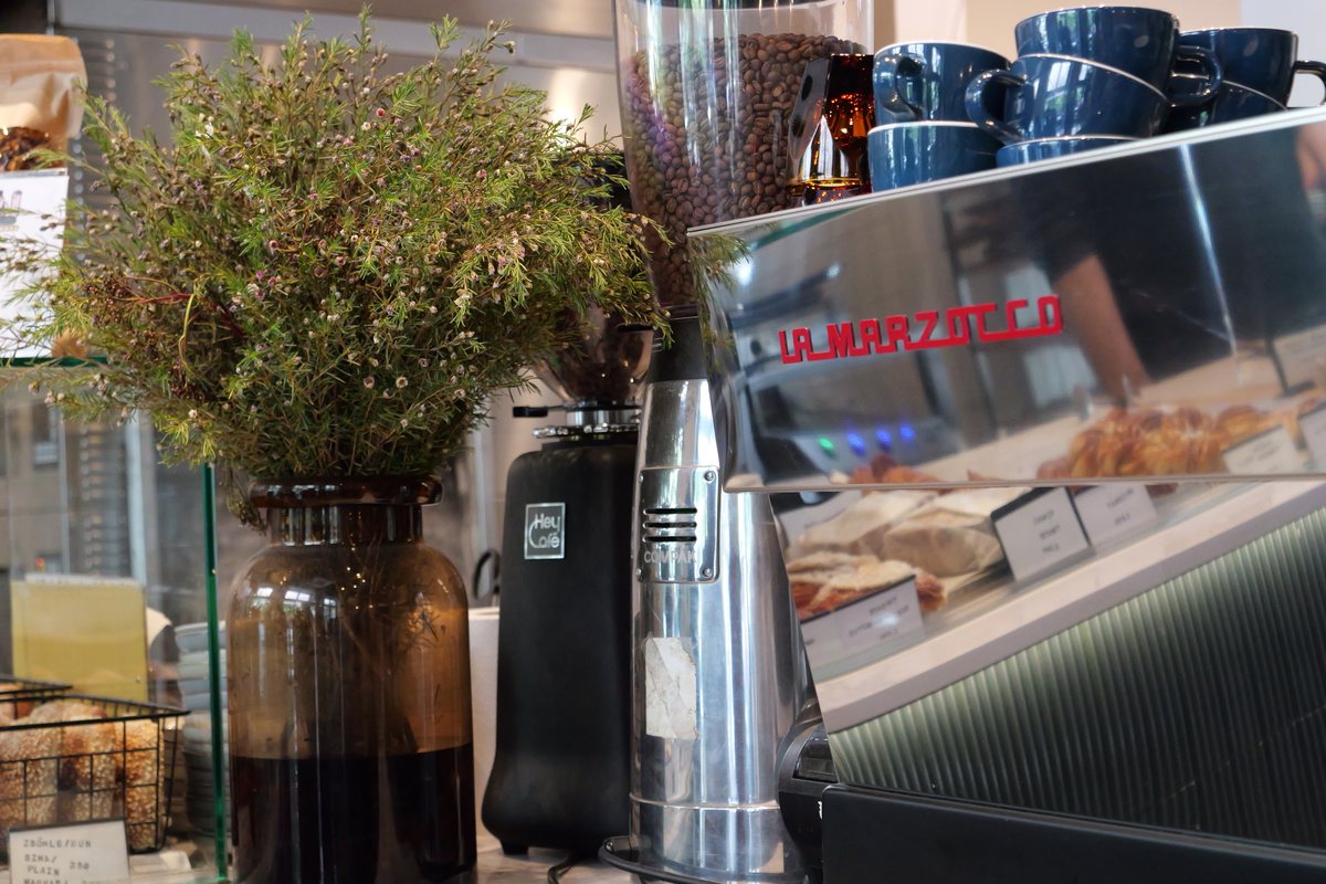 Espressomaschine, Kaffeemühle und ein Strauss Kräuter auf einer Bartheke