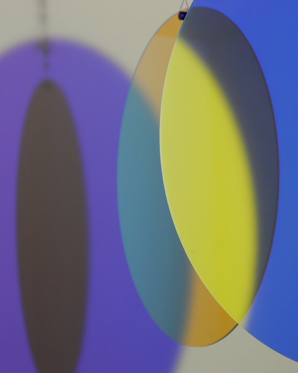 Überlappende violette, gelbe und blaue Glasscheiben, die Farben mischen sich