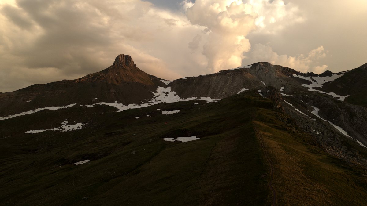 Der Spitzmeilen im Abendlicht, Schneereste auf dem Grat, darüber Gewitterwolken
